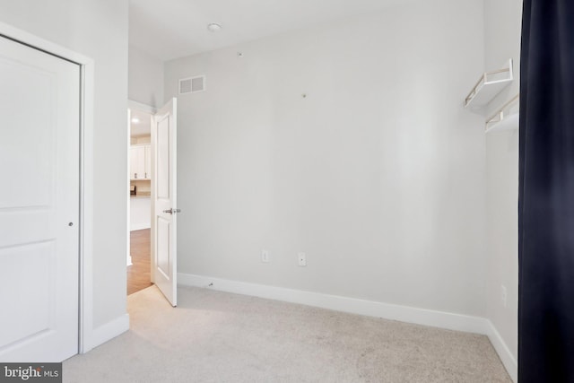 unfurnished bedroom featuring a closet and light carpet