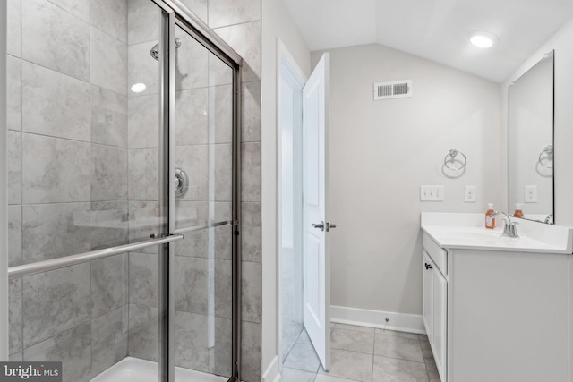 bathroom with tile patterned flooring, vanity, lofted ceiling, and walk in shower