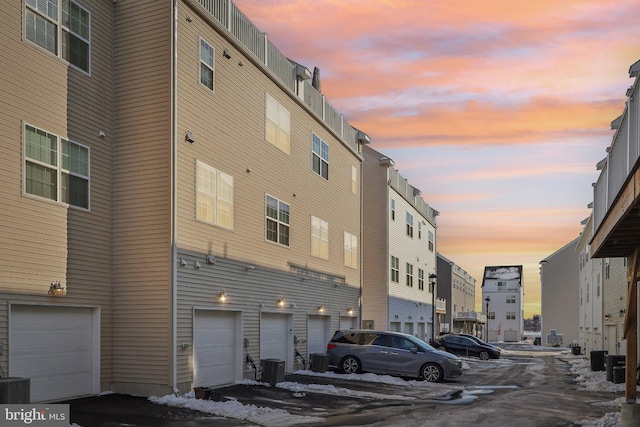 outdoor building at dusk featuring a garage and central air condition unit