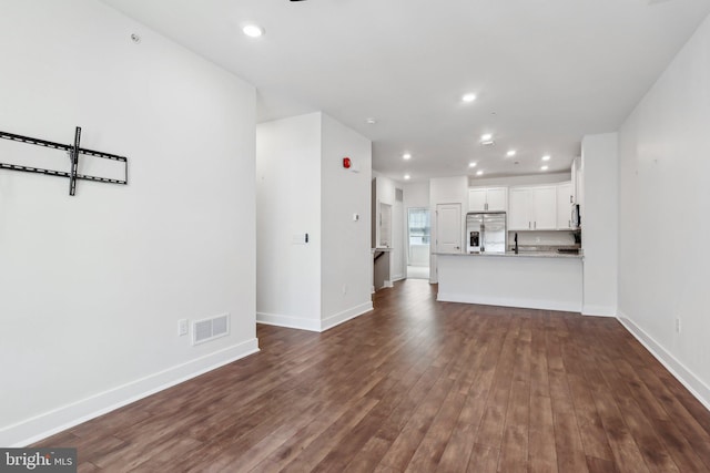 unfurnished living room with dark hardwood / wood-style floors and sink