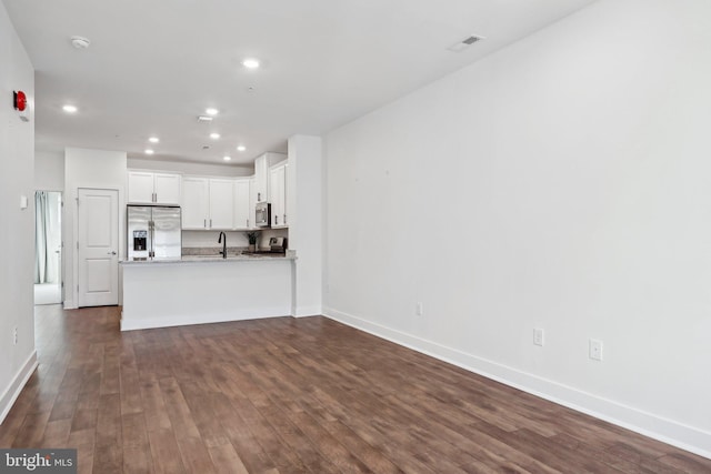 unfurnished living room with sink and dark hardwood / wood-style floors