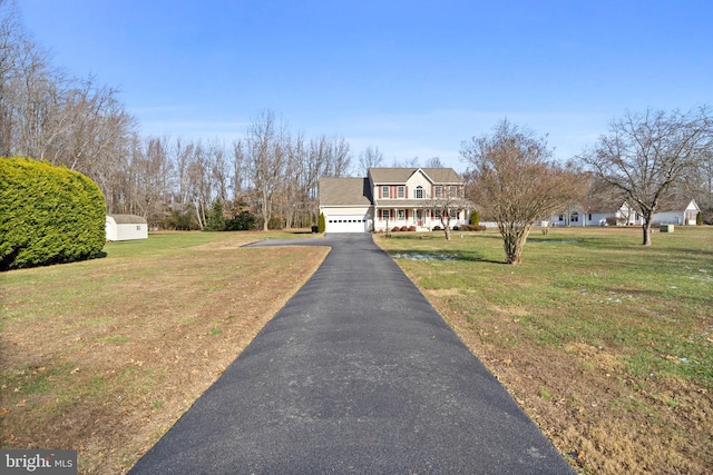 cape cod-style house with a garage, a front yard, and covered porch