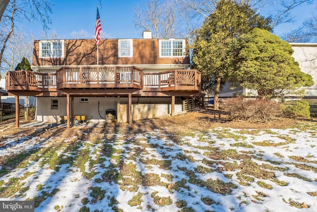 snow covered house with a deck