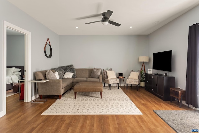 living room with ceiling fan and dark hardwood / wood-style flooring