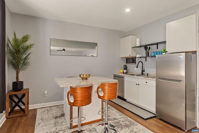 kitchen featuring white cabinetry, sink, a kitchen bar, and appliances with stainless steel finishes