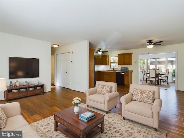 living room with ceiling fan, sink, and light wood-type flooring