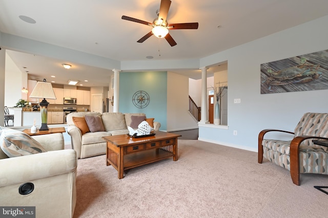 living room featuring decorative columns, light carpet, and ceiling fan