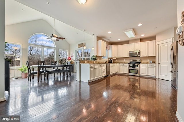 kitchen featuring dark hardwood / wood-style floors, pendant lighting, white cabinetry, kitchen peninsula, and stainless steel appliances