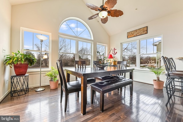 dining area with ceiling fan, dark wood-type flooring, and high vaulted ceiling