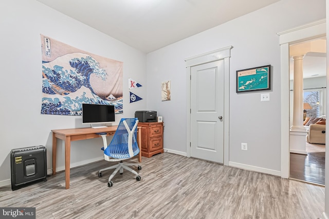 office space with wood-type flooring and decorative columns