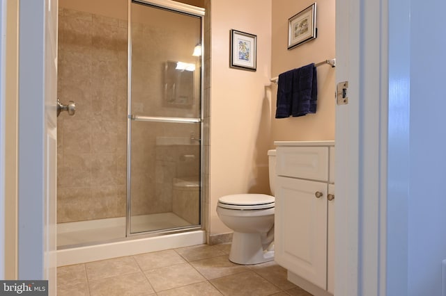 bathroom with tile patterned floors, toilet, and a shower with shower door