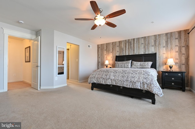 bedroom featuring ceiling fan, wooden walls, and light carpet