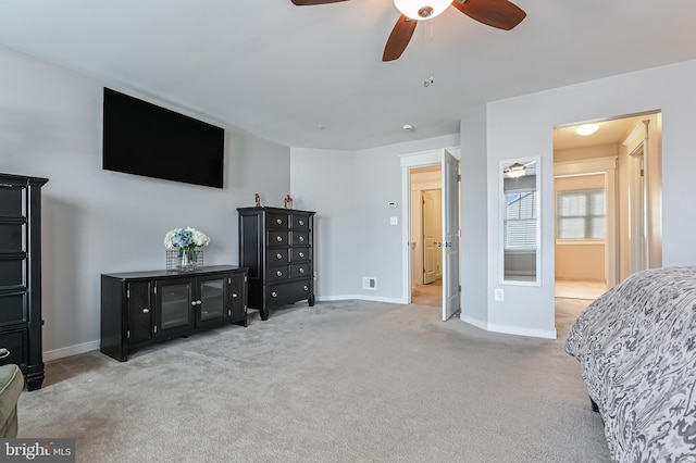 bedroom featuring ceiling fan, connected bathroom, and light carpet