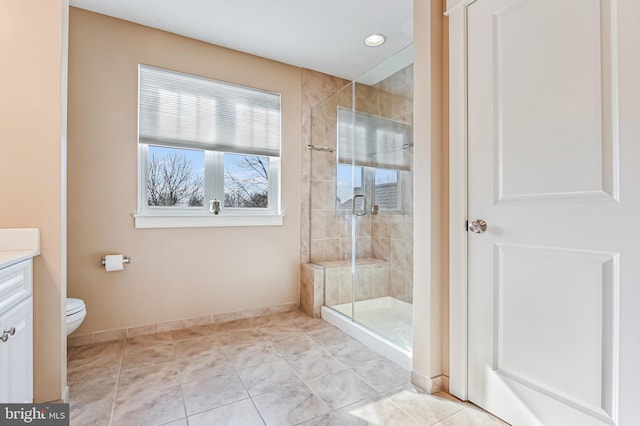 bathroom with tile patterned flooring, vanity, toilet, and walk in shower