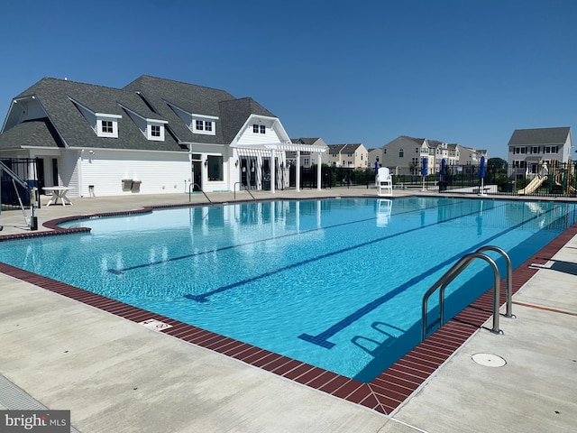 view of pool with a patio and a playground