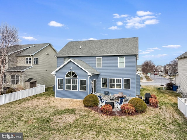 rear view of house featuring a patio area and a lawn