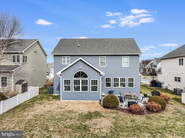 rear view of house with cooling unit, a yard, and a patio