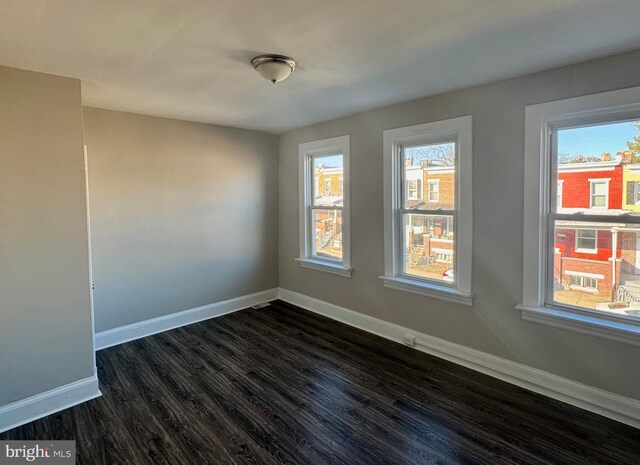 empty room with dark hardwood / wood-style flooring