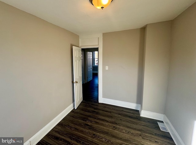 spare room featuring dark wood-type flooring