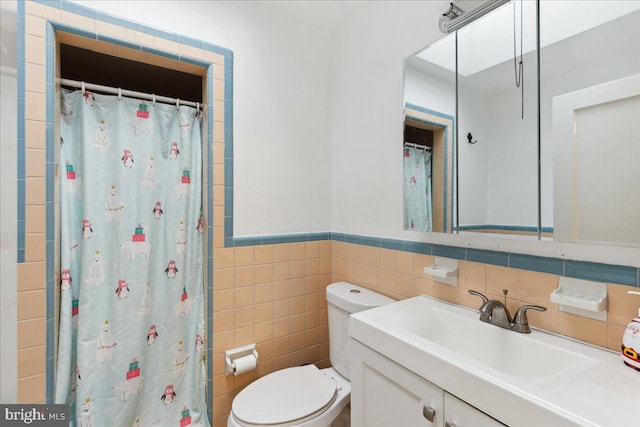 bathroom with tile walls, vanity, curtained shower, and toilet