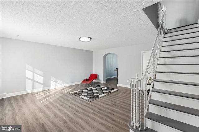 unfurnished room with hardwood / wood-style flooring and a textured ceiling