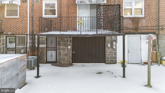 snow covered back of property with cooling unit