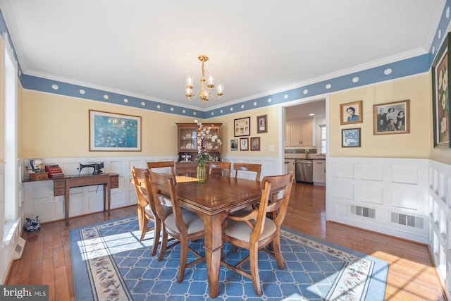 dining room with crown molding, dark wood-type flooring, and a notable chandelier