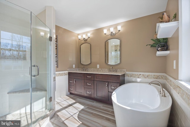 bathroom with tile walls, vanity, hardwood / wood-style flooring, and plus walk in shower