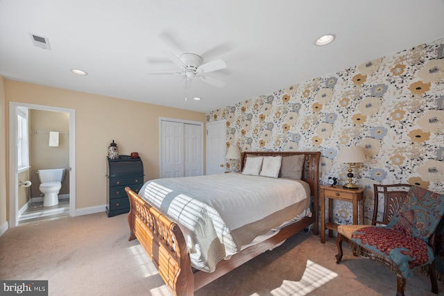 carpeted bedroom with connected bathroom, ceiling fan, and a closet