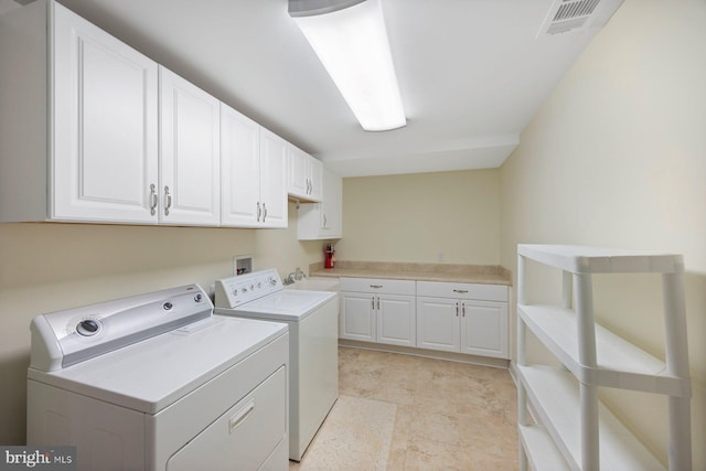 laundry room featuring sink, washing machine and dryer, and cabinets