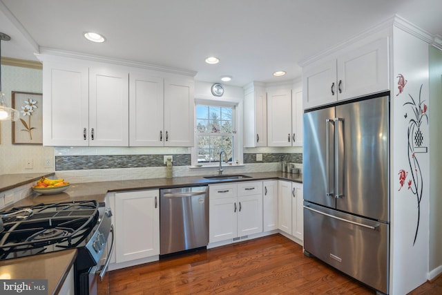 kitchen with white cabinetry, appliances with stainless steel finishes, dark hardwood / wood-style flooring, and sink