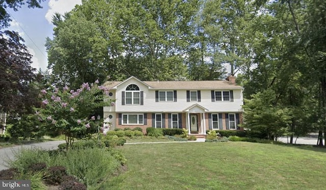 colonial-style house with a front lawn