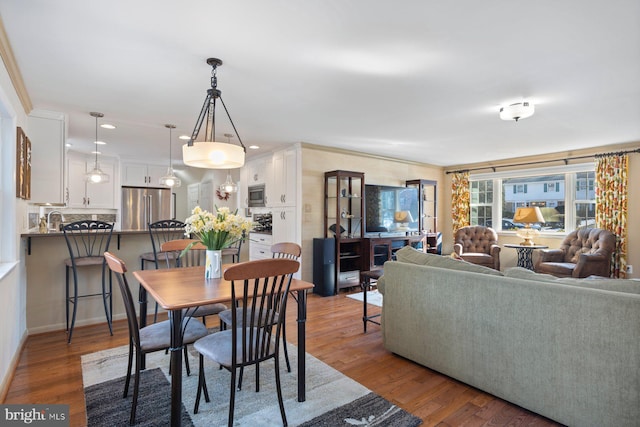 dining space featuring sink and wood-type flooring