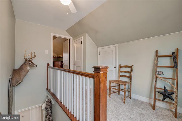 hallway with vaulted ceiling and light colored carpet