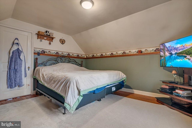 bedroom with hardwood / wood-style flooring and lofted ceiling