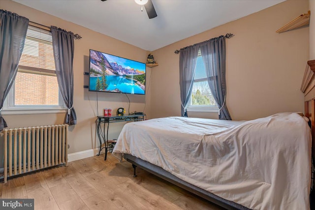 bedroom with radiator, ceiling fan, and light wood-type flooring