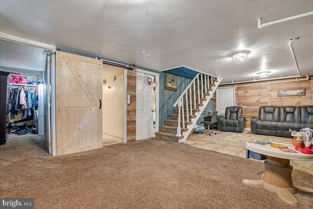 basement featuring a barn door and carpet