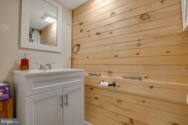 bathroom featuring vanity and wooden walls