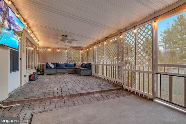 unfurnished sunroom with ceiling fan