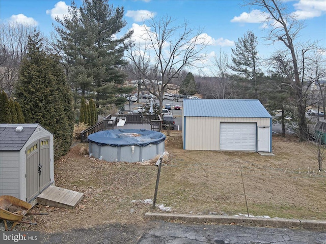 view of yard featuring a covered pool and a storage shed