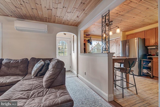 living room featuring an AC wall unit, wooden ceiling, and light wood-type flooring