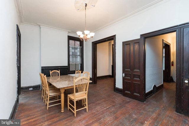 dining space with crown molding, dark wood-type flooring, and a chandelier