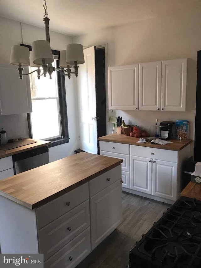 kitchen with butcher block countertops, white cabinetry, stainless steel dishwasher, dark hardwood / wood-style flooring, and pendant lighting