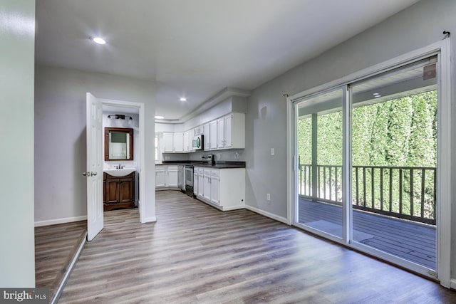 kitchen featuring stainless steel appliances, hardwood / wood-style floors, and white cabinets