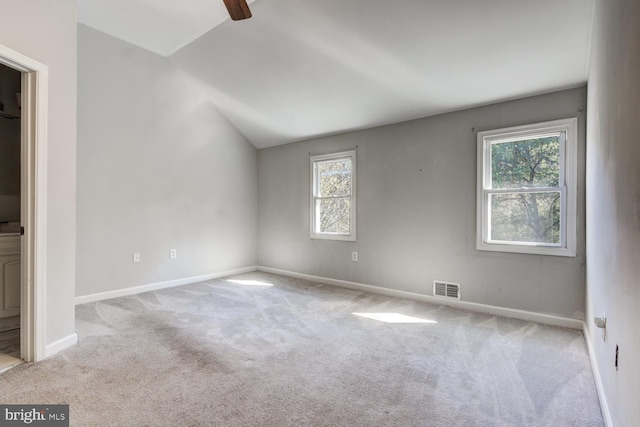 empty room featuring lofted ceiling and light carpet