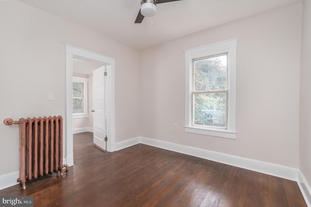 spare room with radiator, dark wood-type flooring, and ceiling fan