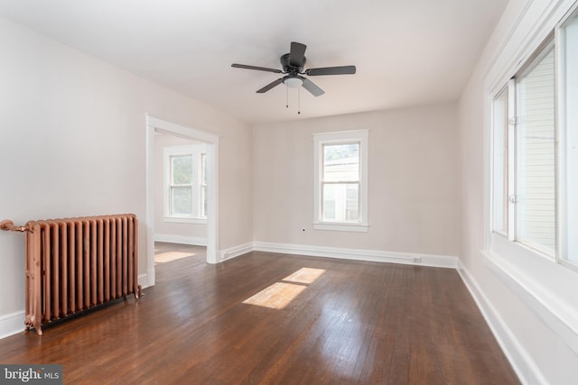 spare room featuring ceiling fan, dark hardwood / wood-style floors, and radiator