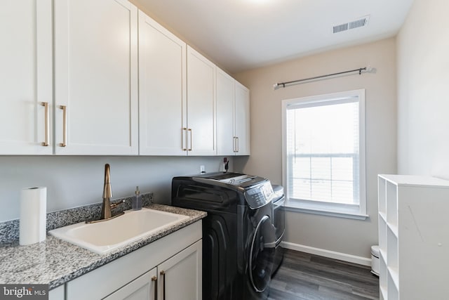 washroom featuring cabinets, dark hardwood / wood-style floors, separate washer and dryer, and sink