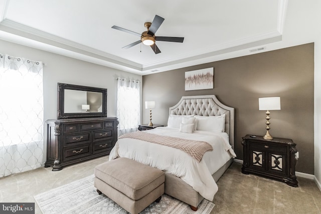 bedroom featuring a raised ceiling, crown molding, carpet, and ceiling fan