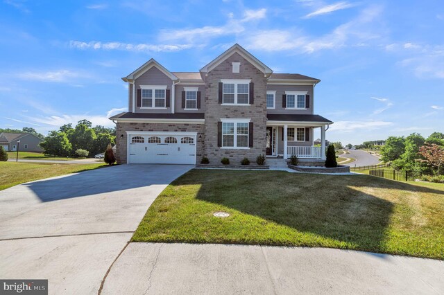 view of front of property featuring a porch, a garage, and a front yard